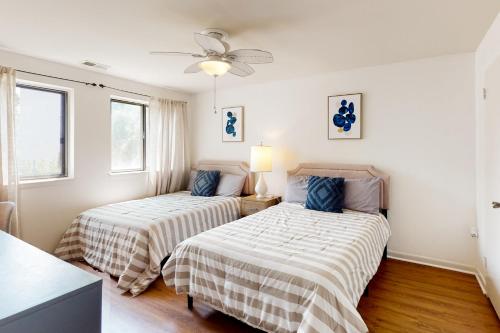 two beds in a room with two windows at Tiburon 2C in Ocean City