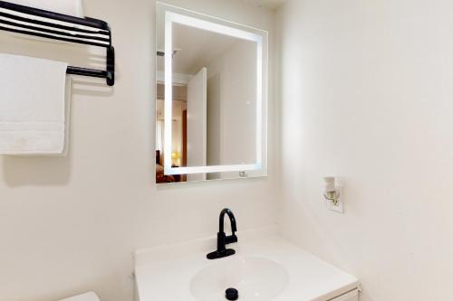 a white bathroom with a sink and a mirror at Tiburon 2C in Ocean City