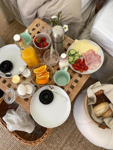 a breakfast table with food and drinks on a bed at Björkudden glamping in Fristad
