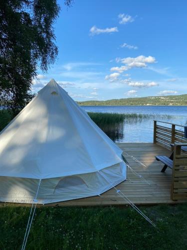 a tent sitting on a dock next to a lake at Björkudden glamping in Fristad