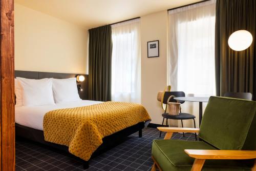 a hotel room with a bed and a chair at Best Western Plus Hotel Cargo in Dunkerque