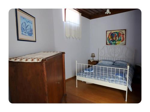 a bedroom with a bed and a dresser at Paydos Tatil Evi in Ayvalık