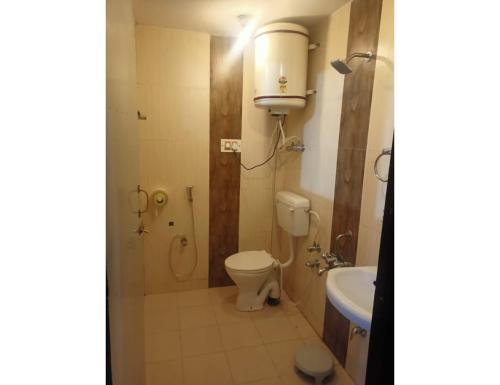 y baño con aseo y lavamanos. en Hotel Shafaaf Plaza, Srinagar en Srinagar