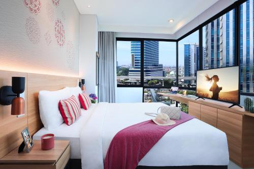 a hotel room with a bed and a large window at Citadines Gatot Subroto Jakarta in Jakarta