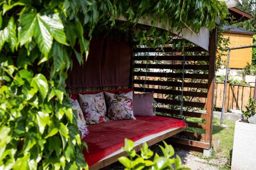 a bench in a pergola in a garden at Gästehaus Waldrand Garni in Wiesing