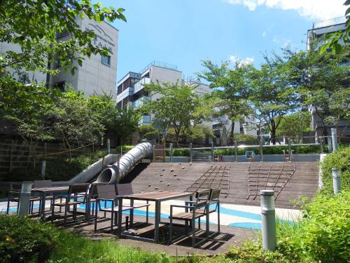 una piscina con mesas y sillas y un tobogán de agua en Healthcare Town Resort en Seogwipo