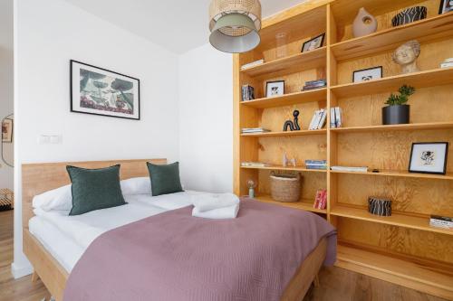 een slaapkamer met een bed en een boekenplank bij Stare Podgórze Śliska Apartment Cracow by Renters in Krakau