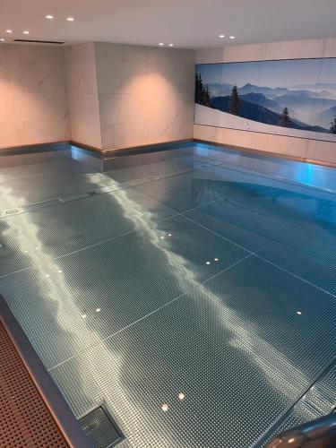 une grande piscine avec un fond de piscine vide dans l'établissement Appartement standing face mont blanc piscine, à Megève