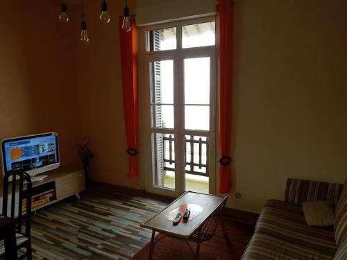 uma sala de estar com um sofá, uma mesa e uma janela em vue sur Mer " VILLA DES MOUETTES " les pieds dans l eau em Veulettes-sur-Mer