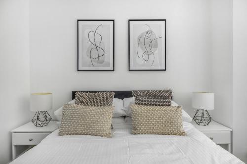 a white bedroom with two pictures on the wall at NEW Stunning Plymouth Central Apartment - Sleeps 6 in Plymouth
