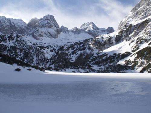 a snowy mountain range with a lake in the foreground at Apartment in Bichlbach near Ski Slopes in Bichlbach
