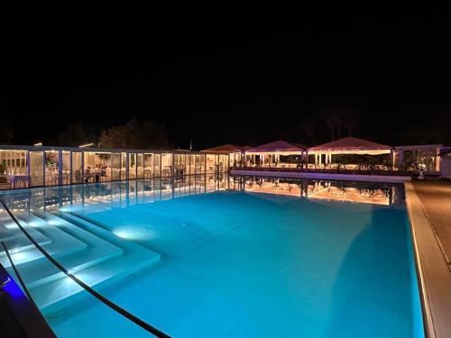 a large swimming pool at night with blue lights at Valle di Mare Country Resort in Fontane Bianche