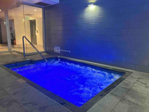 a large blue swimming pool in a building at City apartment, pool & carpark in Adelaide