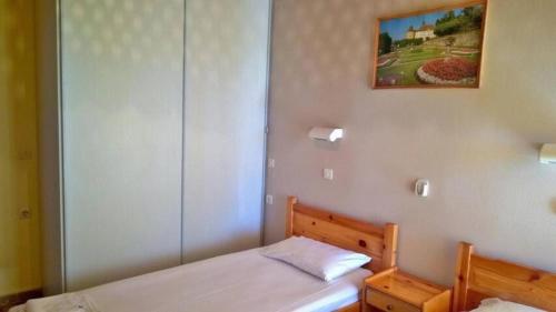 a bedroom with two beds and a painting on the wall at Rose Garden 2 in Kavos