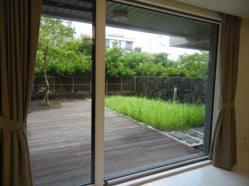 a sliding glass door to a patio with a yard at Healthcare Town Resort in Seogwipo