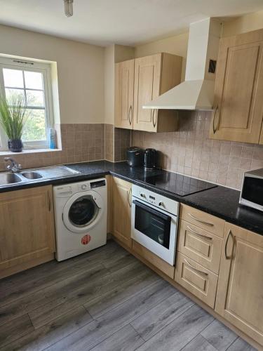 een keuken met een wasmachine en een wastafel bij 3/4 bedrooms, Free Parking, Wifi, Home away from home feel in Purfleet