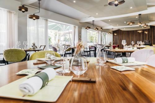 un comedor con una mesa con vasos y sillas en Le Carré d'Alethius Logis Hôtel Restaurant, en Charmes-sur-Rhône