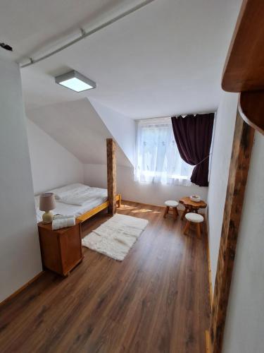 a room with a bed and a table and a window at Cabana Floare de stâncă Retezat cu Ciubar in pădure in Hunedoara