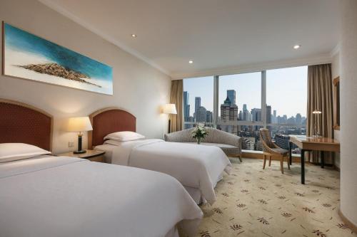 Habitación de hotel con 2 camas y escritorio en Sheraton Nanjing Kingsley Hotel & Towers, en Nanjing