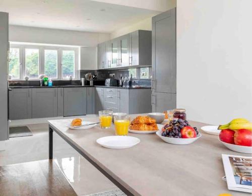 a kitchen with plates of food on a table at Large Countryside House Swim Pool Jacuzzi Sleeps 10 guest in Ware