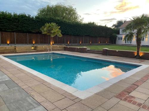 a swimming pool in a yard with a house at Large Countryside House Swim Pool Jacuzzi Sleeps 10 guest in Ware