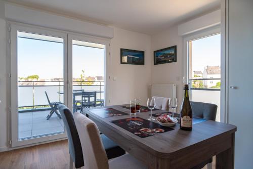 - une salle à manger avec une table et une bouteille de vin dans l'établissement Sioul - Appt à moins d1km de la plage, à Concarneau