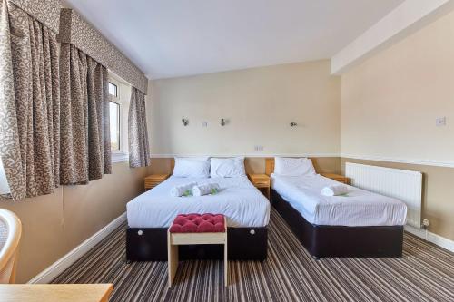 2 camas en una habitación pequeña con mesa en Properties Unique Dene Rooms - Family Room en Newcastle
