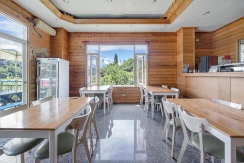 a restaurant with wooden walls and wooden tables and chairs at Bishui Shanju Lakeside B&B in Yuchi