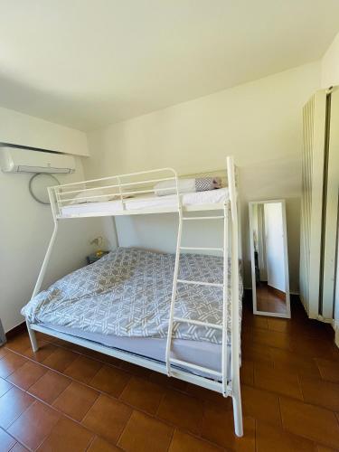 un lit superposé blanc dans une chambre avec un miroir dans l'établissement Studio Plage, à Marseille