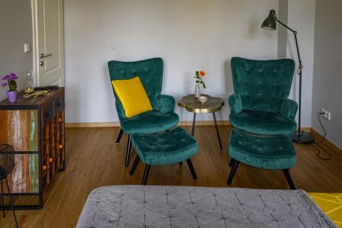 uma sala de estar com duas cadeiras verdes e uma mesa em Abendsonne em Naumburg