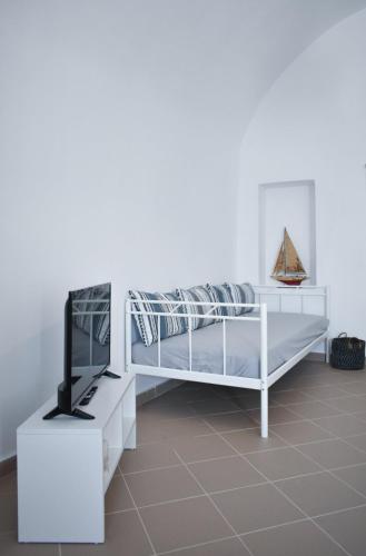 a bedroom with a white bunk bed and a tv at Casa Di Villagio in Pirgos