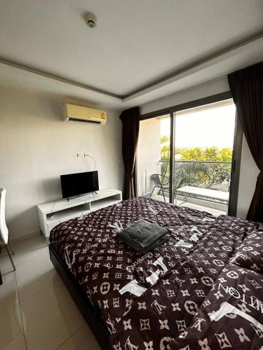 - une chambre avec un lit et une grande fenêtre dans l'établissement MALDIVES (Laguna Beach Resort 3), à Jomtien Beach