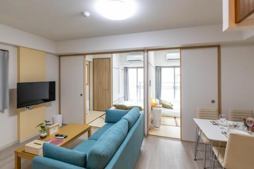 a living room with a blue couch and a table at H2H Shinsaibashi in Osaka