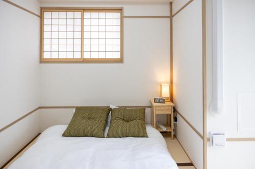 a small bedroom with a bed and a window at H2H Shinsaibashi in Osaka