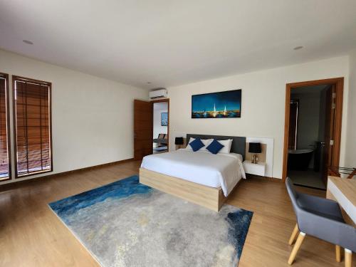 a bedroom with a white bed and a blue rug at SEA VILLA HỒ TRÀM in Ho Tram