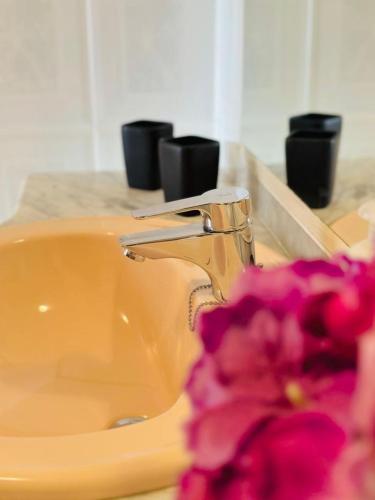 a bathroom sink with a pink flower next to a faucet at Valencia Sol y Playa in Sagunto