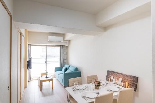 a living room with a table and a blue couch at H2H Shinsaibashi in Osaka