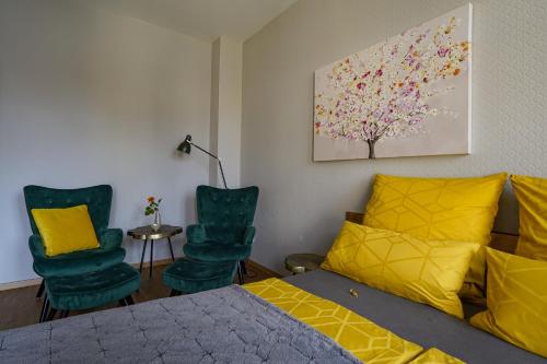 um quarto com uma cama e 2 cadeiras em Abendsonne em Naumburg