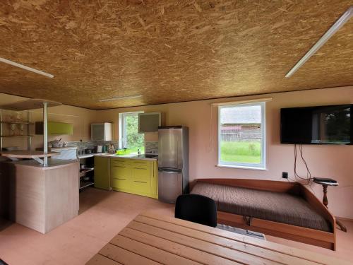Zimmer mit einem Bett und einer Küche mit einem TV in der Unterkunft Liafa laikas 