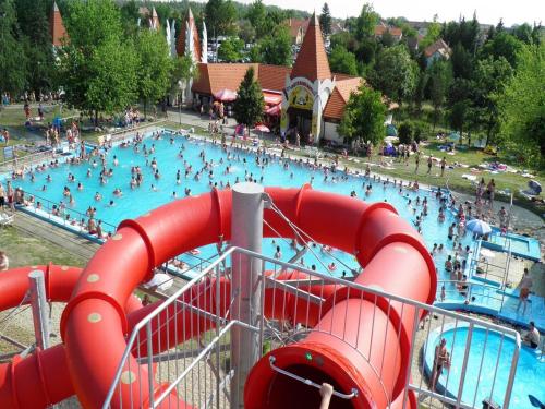 a large swimming pool with people in it at Tölgyes - völgy Vendégház in Makkoshotyka