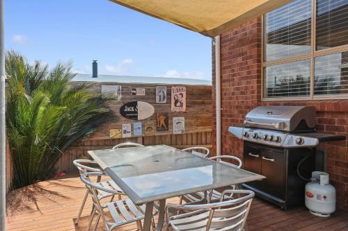 a patio with a table and chairs and a grill at Hidden Gem Bermagui fishing friendly pet friendly Bermagui in Bermagui