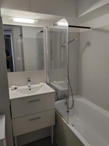 une salle de bain blanche avec un lavabo et une douche dans l'établissement Cap d'agde VUE MER, au Cap d'Agde