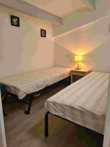 Cette chambre comprend deux lits et une lampe sur une table. dans l'établissement Cap d'agde VUE MER, au Cap d'Agde