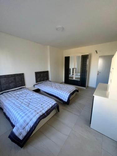 - une chambre avec 2 lits et un miroir dans l'établissement German-Palestinian Appartement, à Al Khalīl
