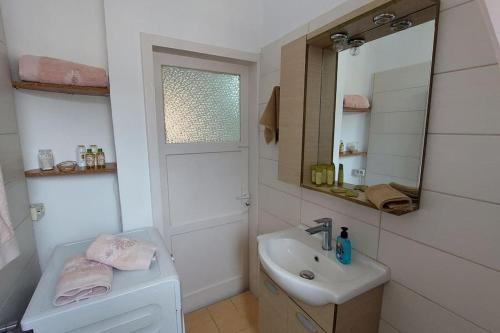 a white bathroom with a sink and a mirror at Old Port View Apartment, διαμέρισμα στο κέντρο 2 υπνοδωματίων in Corfu Town