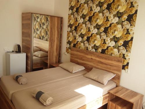 a bedroom with two beds and a wall with flowers at Guest House Buche on Agmashenebeli 219 in K'obulet'i