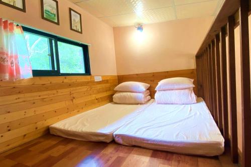 a bedroom with a bed with two pillows on it at Lowkey B&B 低調民宿 in Fuli