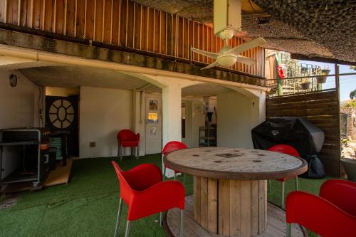 d'une terrasse avec une table et des chaises rouges. dans l'établissement Rez de Villa - Le Luc, au Luc