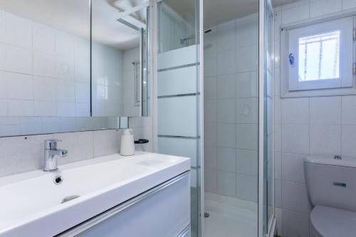 un bagno bianco con lavandino e doccia di Rez de Villa - Le Luc a Le Luc