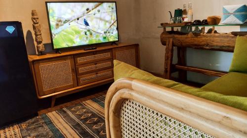 a living room with a television and a couch at Premadhan Cottage Canggu in Canggu